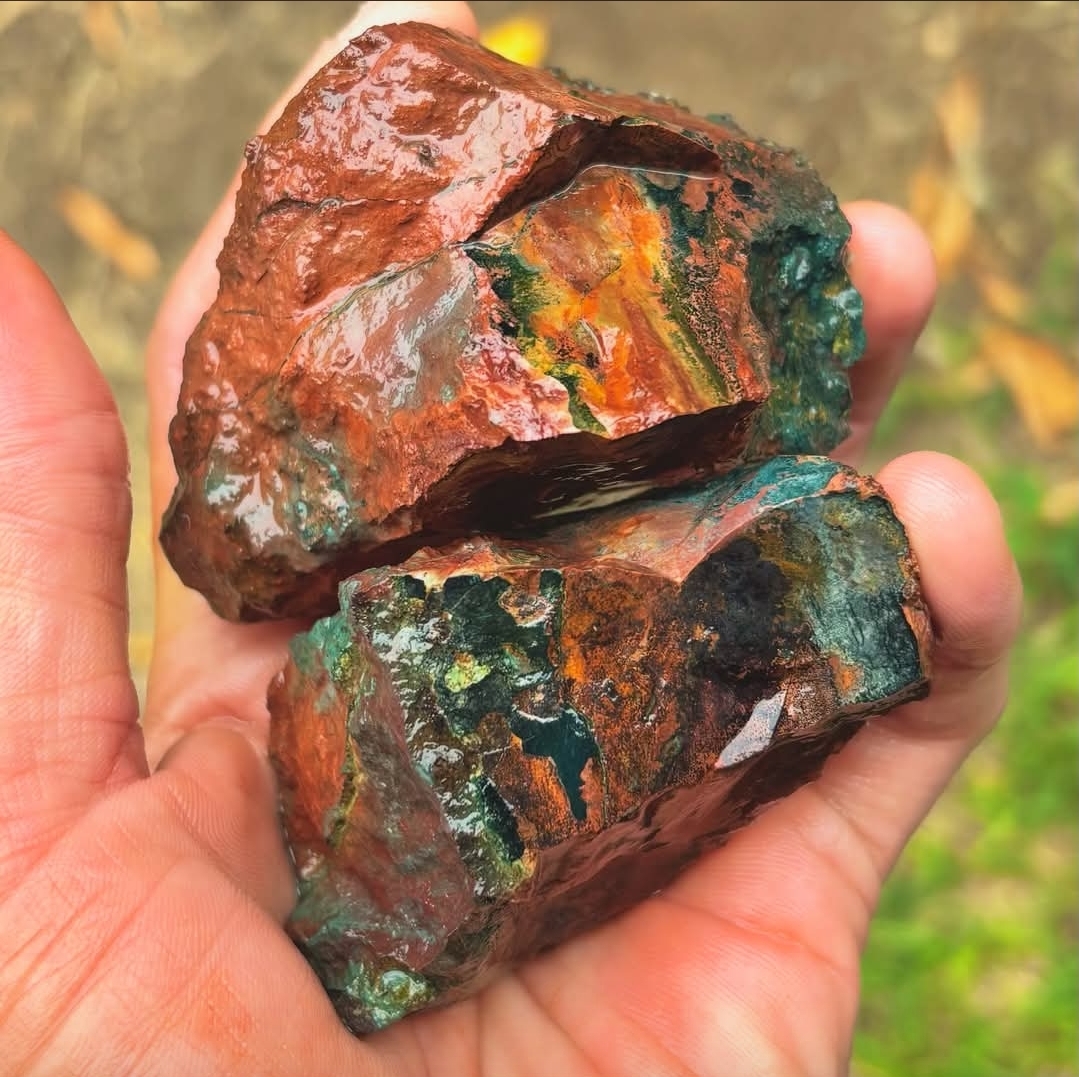 Vivid red, orange, and green rough stone in Peter's hand